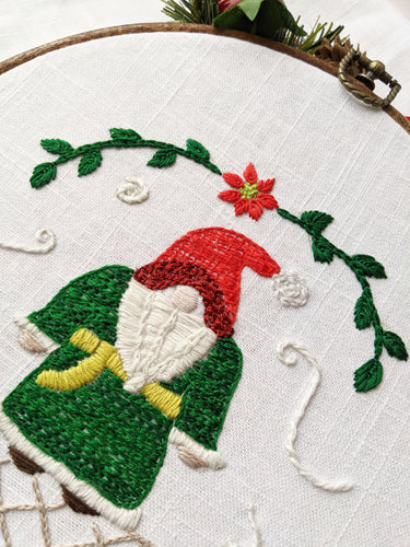 Holiday Christmas Gnome exclusive pattern. Holly border and snowflakes in a white, green, brown and red color palette.