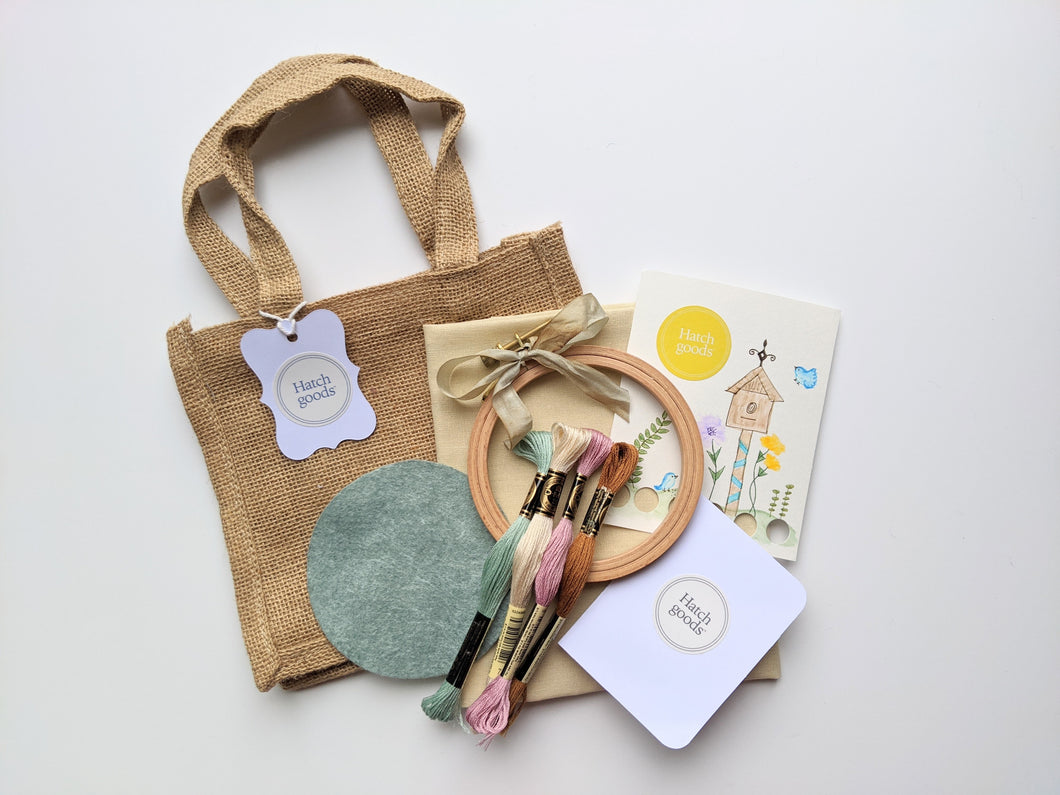 Jute bag embroidery kit includes 4 inch beechwood hooo, felt backing, DMC floss, needle and needleminder card and vintage ribbon.
